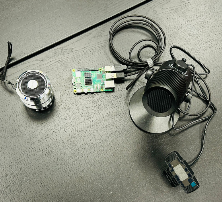 Raspberry Pi 5 AI assistive device prototype with USB camera microphone and speaker